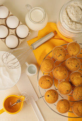 Kitchen utensils, tools and products for the capcake (muffins) on a light wooden background.