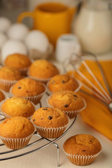 Kitchen utensils, tools and products for the capcake (muffins) on a light wooden background.