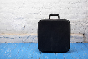 Retro style - Vintage suitcase on a wood and brick background