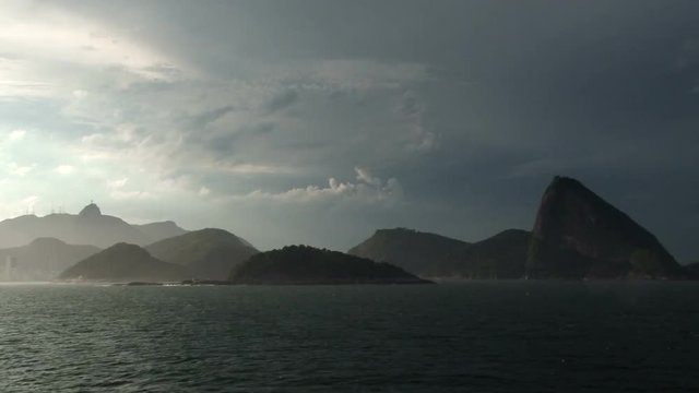 Backlit footage of Sugar Loaf Mountain and Corcovado in Rio de Janeiro Brazil as seen from an arriving ship