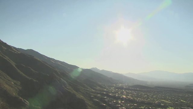 Aerial View of Mountains With Homes and Blue Sky In The Distance