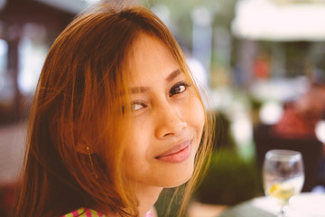 Attractive young girl holding a glass and drinking martini with lemon cocktail