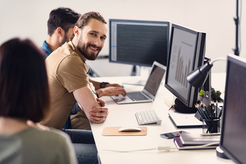 Outgoing bearded worker making estimation on screen
