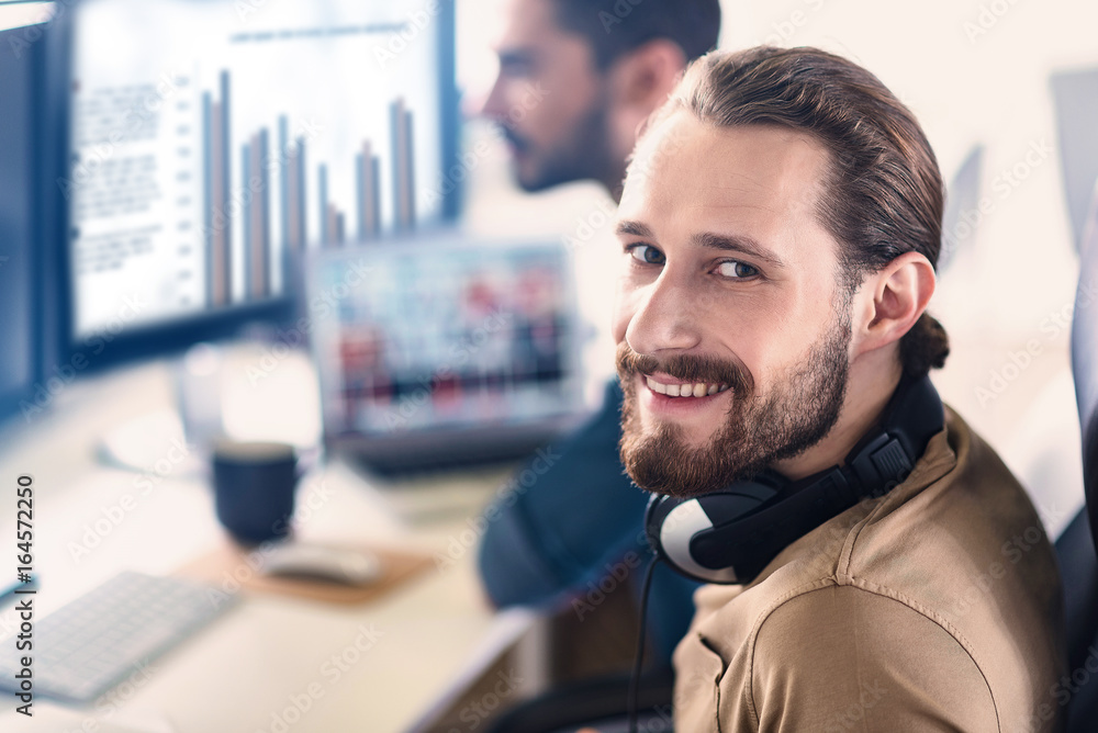 Poster beaming man working on computer