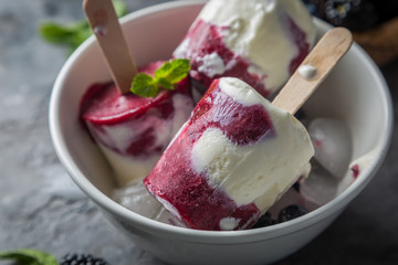 Berry popsicles on rustic background