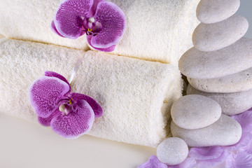 Spa. White towels, stones and orchids lie on the table