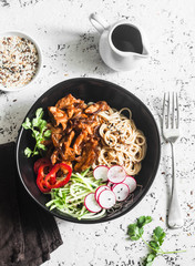 Rice noodles and teriyaki chicken stir fry with quick pickled cucumbers and radishes. On a light...