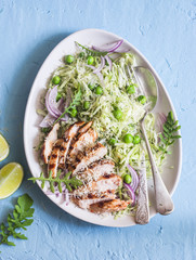 Salad with grilled chicken, cabbage, green peas and parmesan cheese. On a blue background, top view