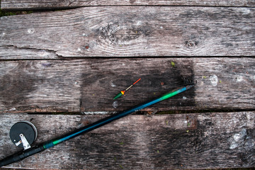 Fishing tackle, rod on a wooden background.