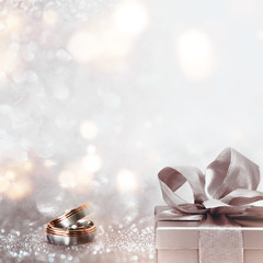 Wedding rings on an abstract silver glittering bokeh background