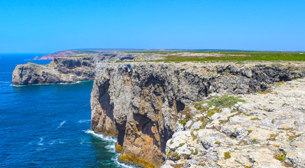 View of famous Cliffs of Moher and wild Atlantic Ocean, Portuguese coastline close to Cape St. Vincent in Portugal on a sunny and clear day with the beautiful blue Atlantic in the background.