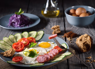 Scrambled eggs and sausage with vegetables