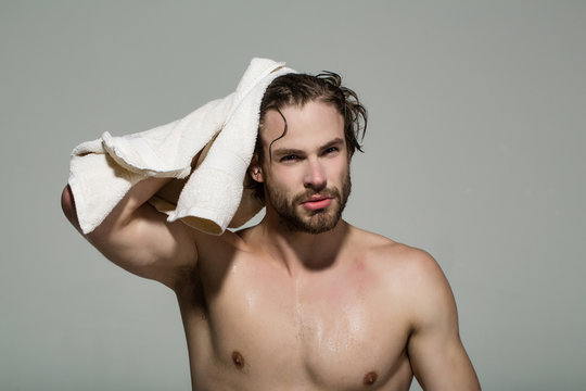 man with muscular wet body hold towel in bath