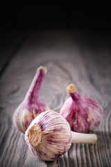 Three heads of garlic on a wooden table