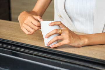 Obraz na płótnie Canvas Young girl holding tea cup in hands. Woman having a break.