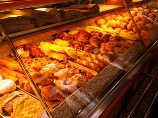 Bright shot of burgers, donuts and sandwiches in a bakery or shop glass counter.