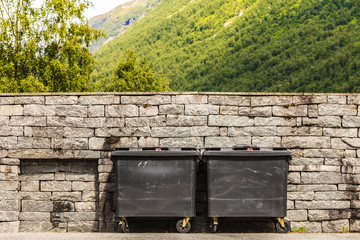 Two black industrial trash cay containers littler garbage