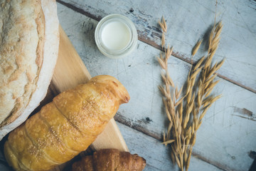 fresh bread and baked goods on wooden chopping board, rustic style