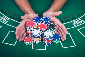 Gambling chips and cards on a green cloth Casino table