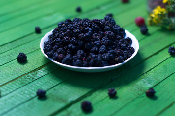 Fototapeta na wymiar Fresh blackberries on a wooden green background.
