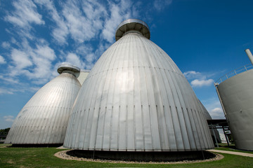 Obraz premium Faultürme in der Kläranlage perspektivisch vor blauem Himmel fotografiert