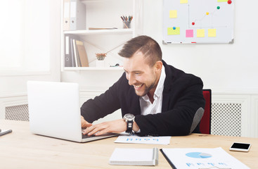 Young businessman with laptop in the office