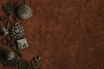 Vintage sewing accessories and old decorations on a surface of brown suede