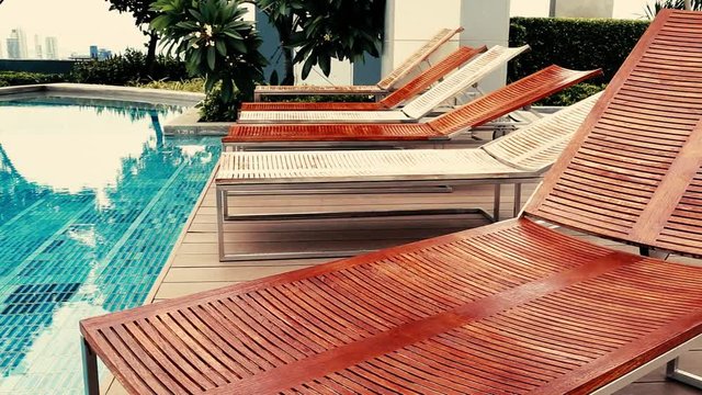 wooden teak Lounge Chairs, Patio Furniture, at Poolside with garden background