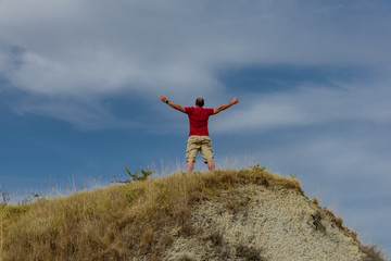 Man raising his arms to the sky with red mesh