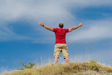 Fototapeta premium Man raising his arms to the sky with red mesh