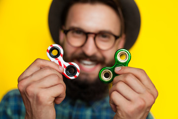 young man holding two fidget spinners