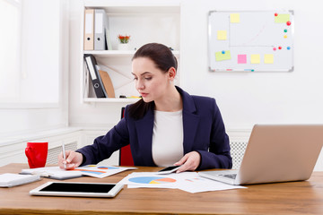 Business woman reading document at office desktop