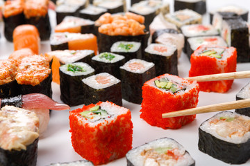 Set of sushi, maki and rolls closeup with chopsticks