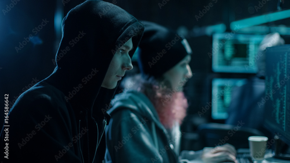 Aufkleber close-up shot of internationally wanted boy and girl hackers team working on their computers. place 