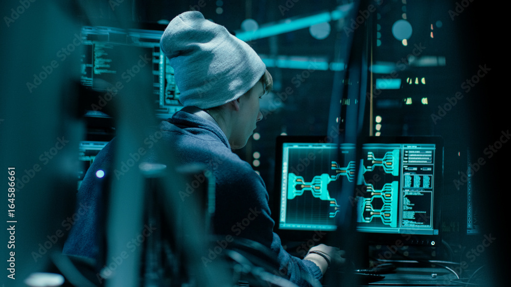 Aufkleber Back View of Teenage Hacker Working in Computer and Infecting with Virus Data Servers of Government Infrastructures. His Hideout is Dark with Many Monitors Around.