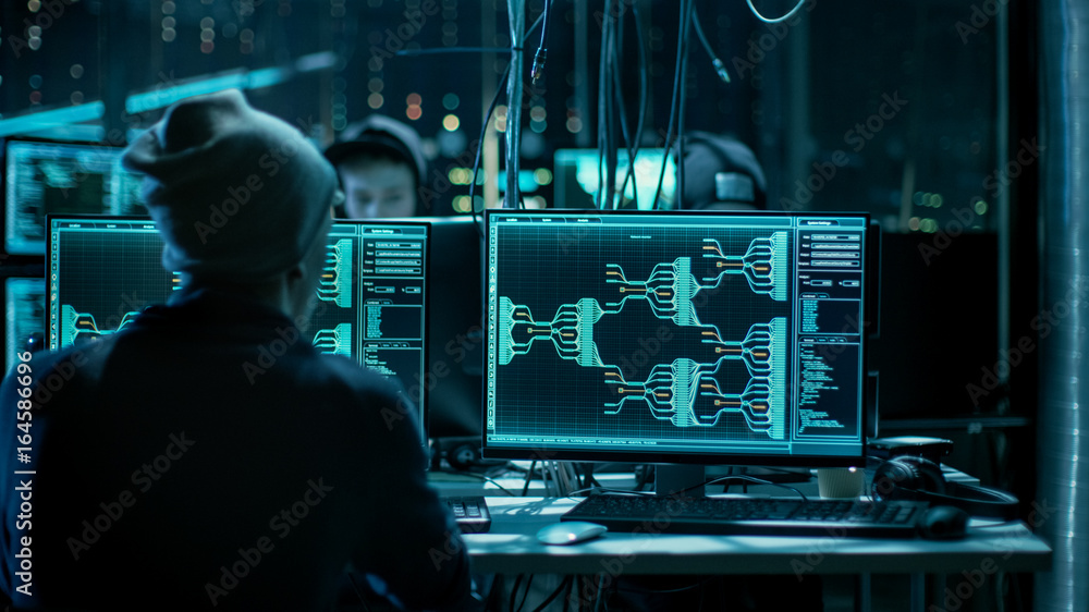 Fototapete Team of Internationally Wanted Hackers Teem Organizing Advanced Malware Attack on Corporate Servers. Hacker is Working in His Computer. Place is Dark and Has Multiple displays.