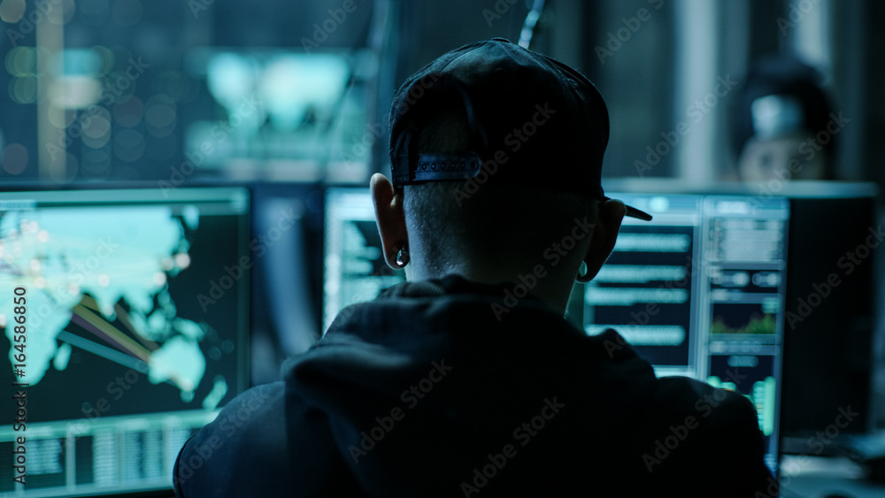Aufkleber Close-up Frame from the Back of Working Hacker Organizing Advanced Virus Attack on Corporate Servers. Place is Dark and Has Multiple displays.