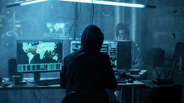 Team of Internationally Wanted Teenage Hackers Infect Servers and Infrastructure with Ransomware. Their Hideout is Dark, Neon Lit and Has Multiple displays.