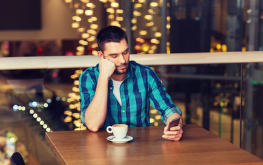 man with smartphone and coffee at restaurant