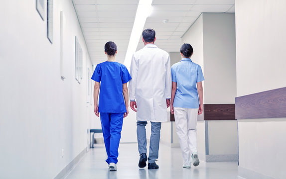 Group Of Medics Or Doctors Walking Along Hospital