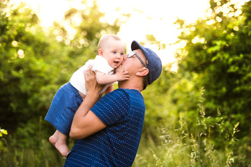 Obraz premium Young father in nature holding baby son in the arms.