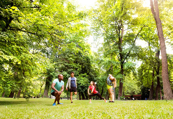 Fototapeta premium Group of young runners stretching and warming up in park.