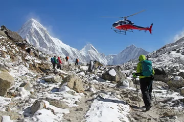 Foto op Plexiglas Goup of climbers in the Himalayas, view on peaks Lingtren, Pumori and Khumbutse. Rescue helicopter in action, Nepal © branex