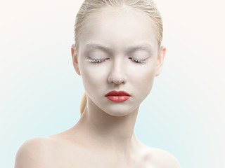 Pretty sensual woman in cosmetics looking down on a white background. © alexx_60