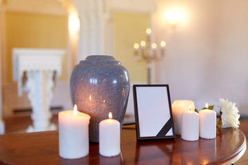 photo frame, cremation urn and candles in church