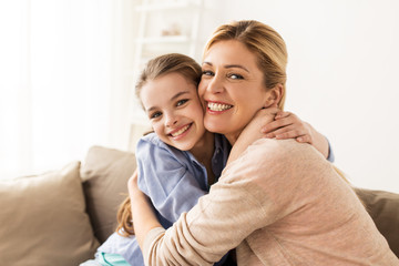 happy smiling family hugging on sofa at home