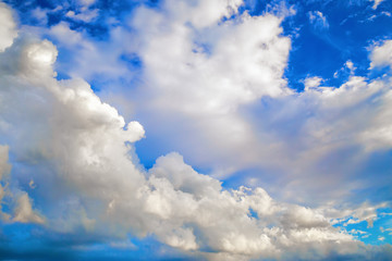 Naklejka na ściany i meble White cumulus clouds against a bright blue sky.