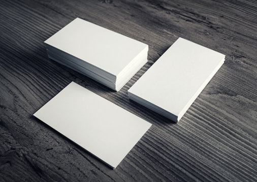 Photo of blank business cards on a wood table background. Template for ID. Business cards mockup.
