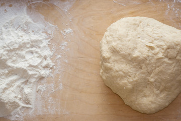 Dough on a wooden desk background with dusting of flour