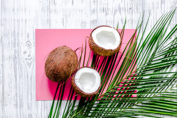 Fototapeta na wymiar Appetizing coconut and palm branch on white background top view